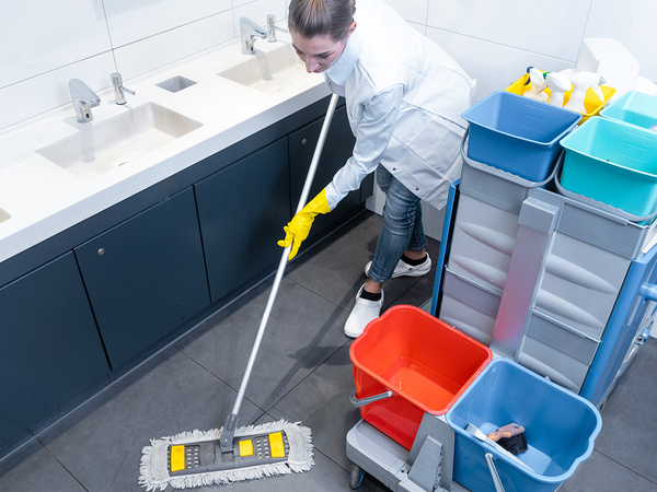 Image of a professional cleaner mopping a bathroom floor