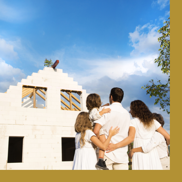 Family stands in front of unfinished home build