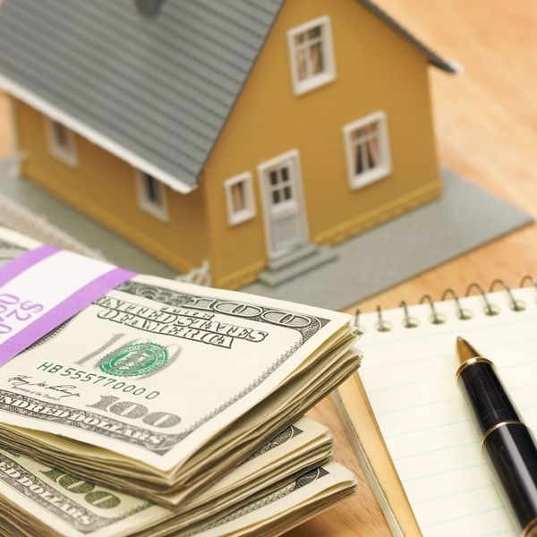 Miniature house and stack of money 