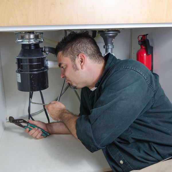 Plumber working on a garbage disposal