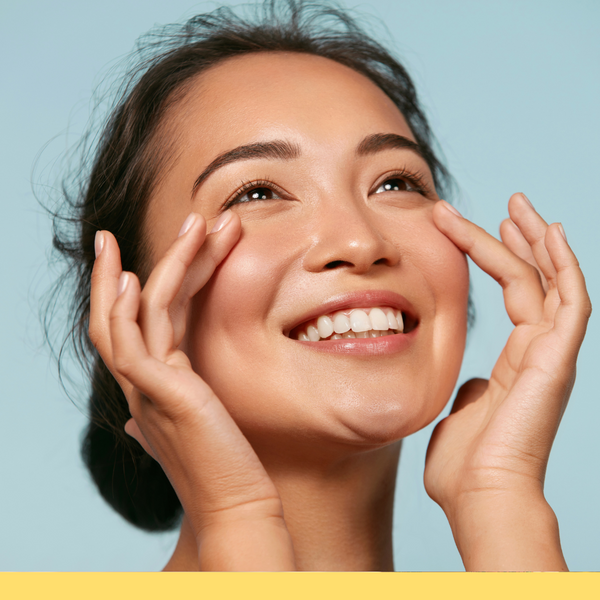 Woman touching her face and looking happy. 