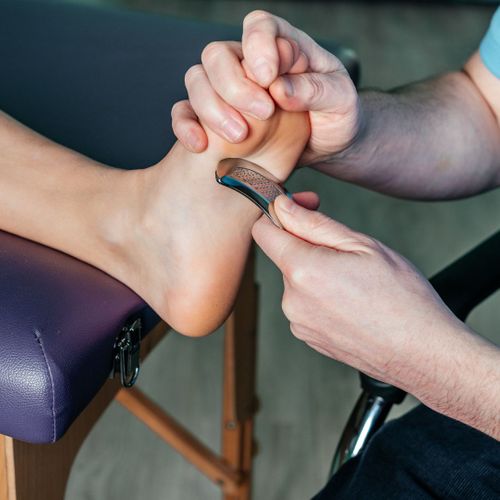 Applying Graston technique to the bottom of an athletes foot.