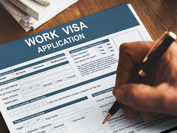 Image of someone filling out a work visa application