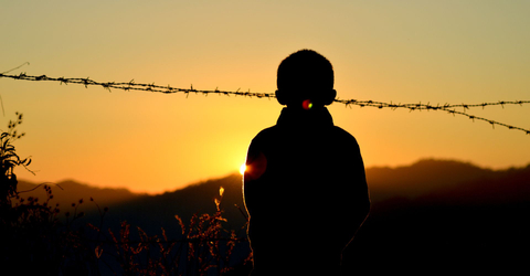 boy and barbed wire fence