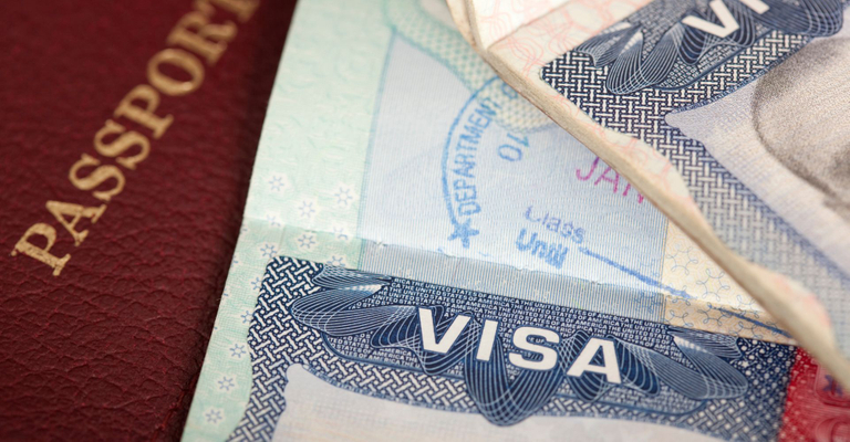 Close-up of two visas on top of a passport