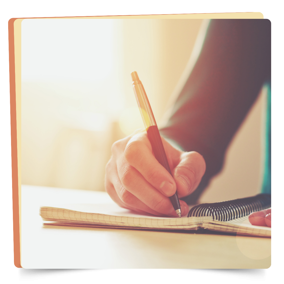 person writing with a pen on paper. 