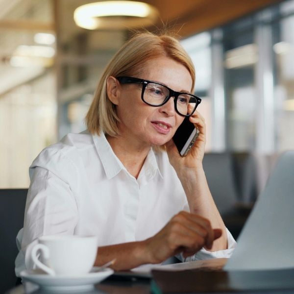 woman with glasses calling to make appointment
