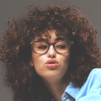 woman-curly-hair-wearing-ray-ban-eyeglasses.png