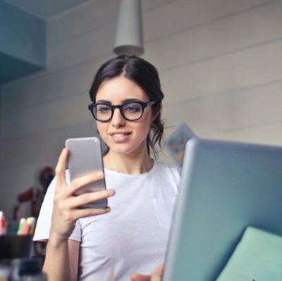 woman-in-white-t-shirt-holding-smartphone-in-front-of-laptop-640px-428x427.jpg