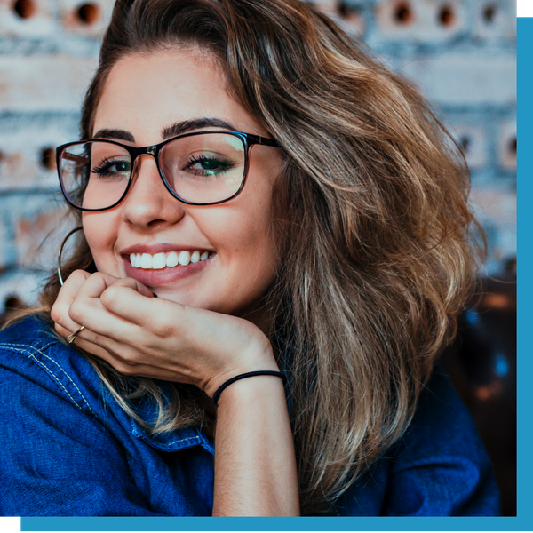Smiling woman resting her chin on her hand wearing glasses