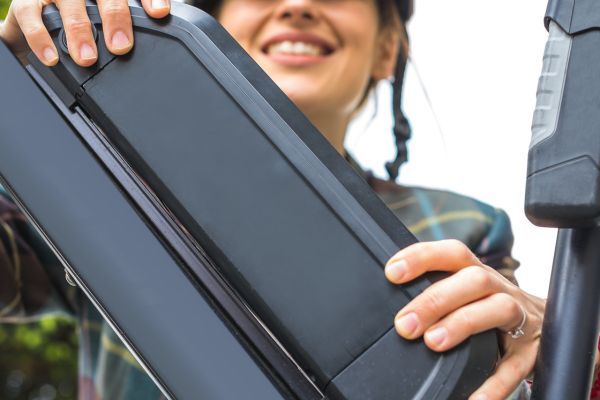 woman smiling and attaching ebike battery