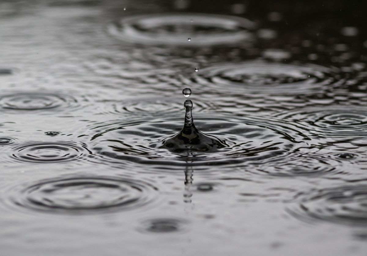 closeup of rain hitting puddles on the road