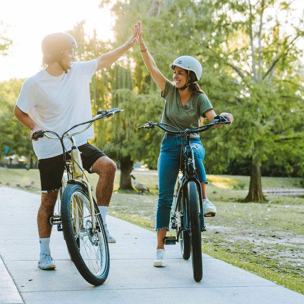 two people on ebikes high fiving