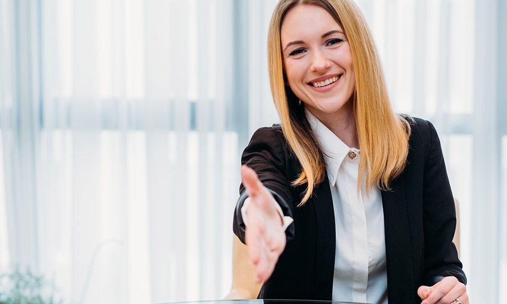 woman with blonde hair reaching out for handshake