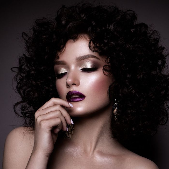 Woman with black hair, purple lipstick, and silver makeup Woman with black hair, purple lipstick, and silver makeup