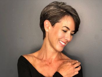 Woman with short brown hair smiling after having her hair styled at THE LONDONER's Hermosa Beach hair salon.