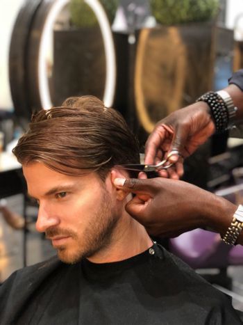 Man getting his short brown hair cut and styled at THE LONDONER in Hermosa Beach.