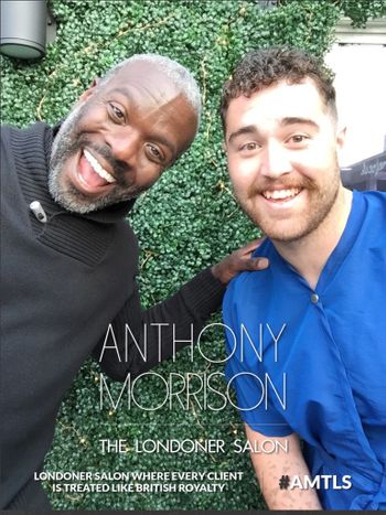 Anthony Morrison smiling next to a happy client at THE LONDONER's outdoor hair salon in Hermosa Beach.