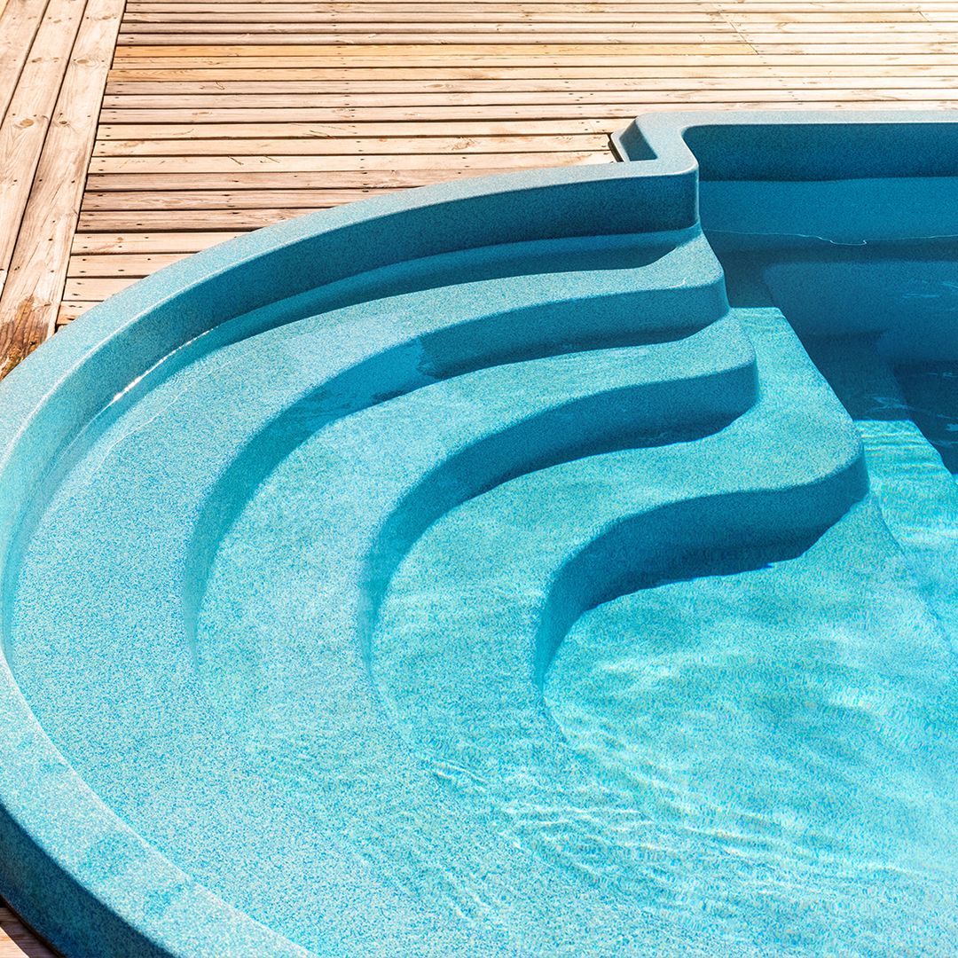 shaped fiberglass pool overlapping wooden deck