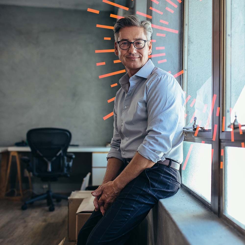 Man sitting on office window ledge