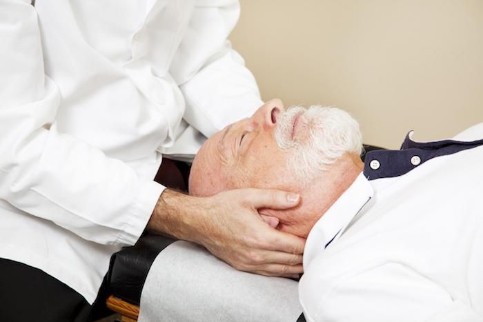 chiropractor adjusts a mans neck
