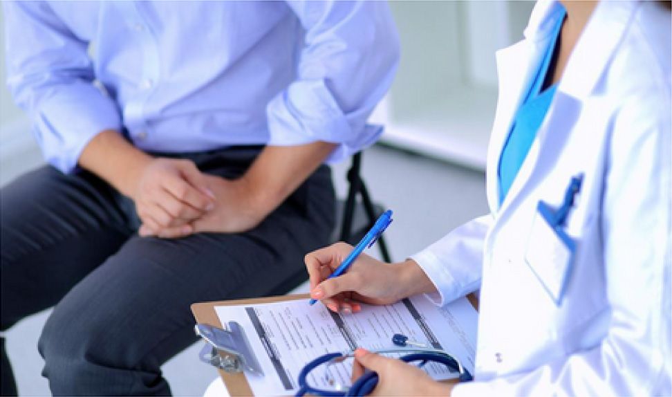 doctor writes notes as she talks to a client