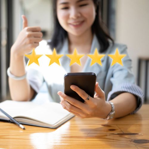 a woman looking at her phone with a hovering 5 star overlay above the phone