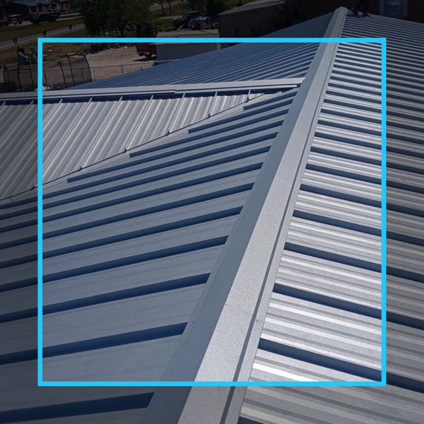 Detail shot of light grey ribbed metal roof panels highlighting the clean lines of a professional PBR installation.