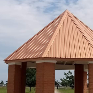 A copper-colored metal roof installed on an octagonal outdoor pavilion with red brick support columns.