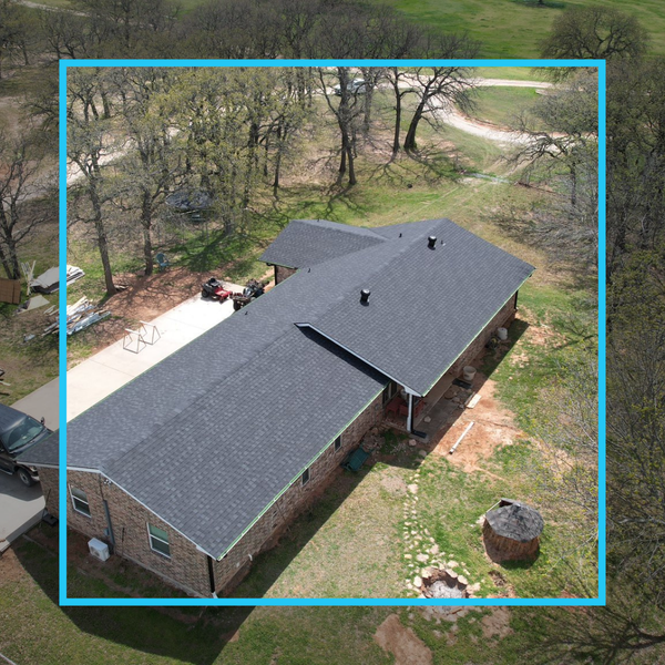 Aerial drone shot of a sprawling residential property featuring a newly installed charcoal shingle roof and brick exterior.