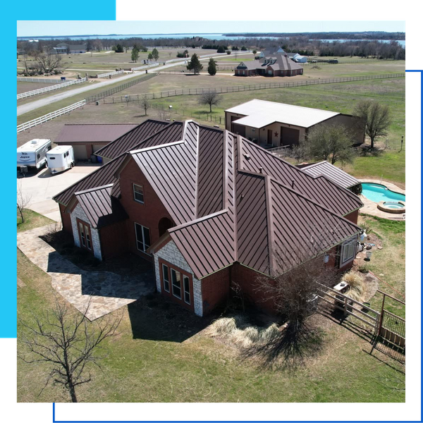 Aerial view of a large brick estate featuring a chocolate brown metal roof, luxury pool, and matching metal outbuildings.
