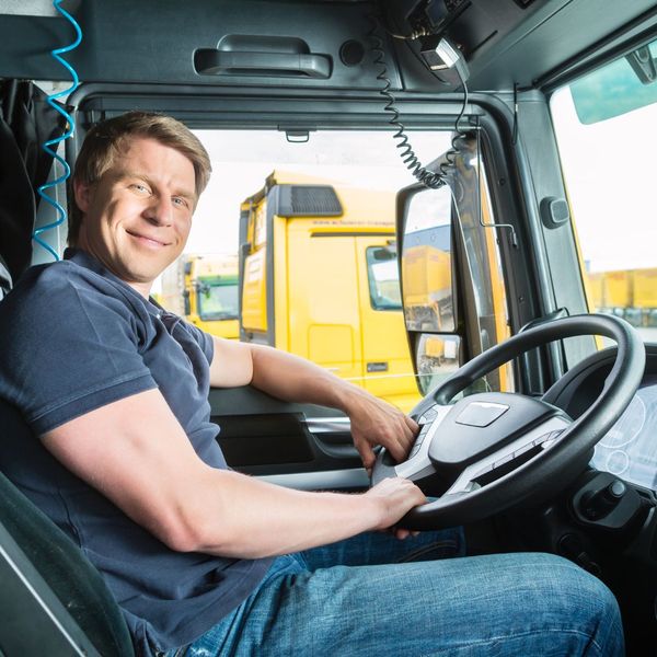 commercial truck driver smiling in his truck