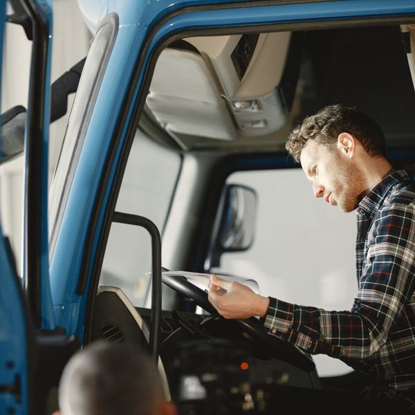 man looking over a truck's manual during CDL training
