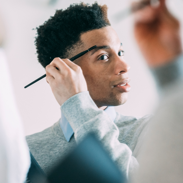 man looking at his eyebrows 