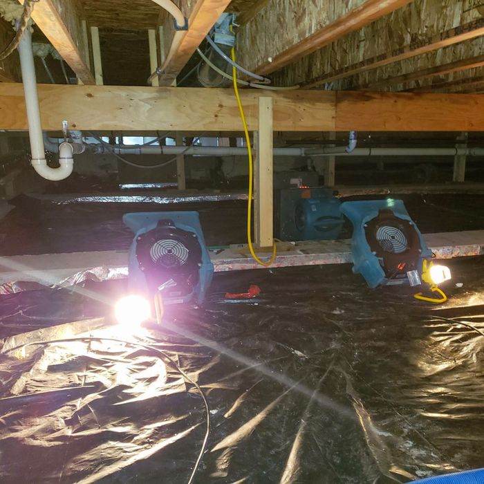 large fans under a house drying the baseboard