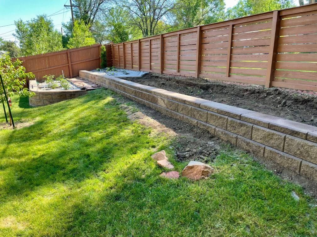 tiered bricked garden beds along a fence