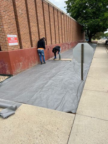 workers prepping a long landscape area for hardscaping