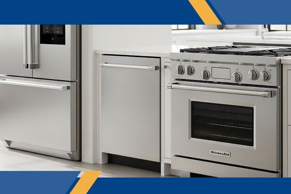 A matching set of stainless steel KitchenAid appliances, including a refrigerator, dishwasher, and range, are displayed in a clean showroom.
