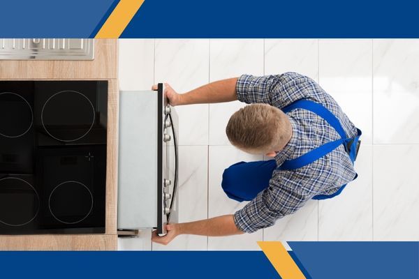 Man pushes repaired oven into place Man pushes repaired oven into place