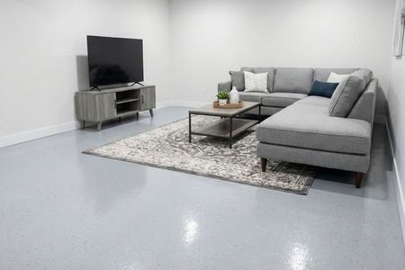 A bright and clean finished basement in Boys Town featuring a moisture-resistant light grey epoxy floor.