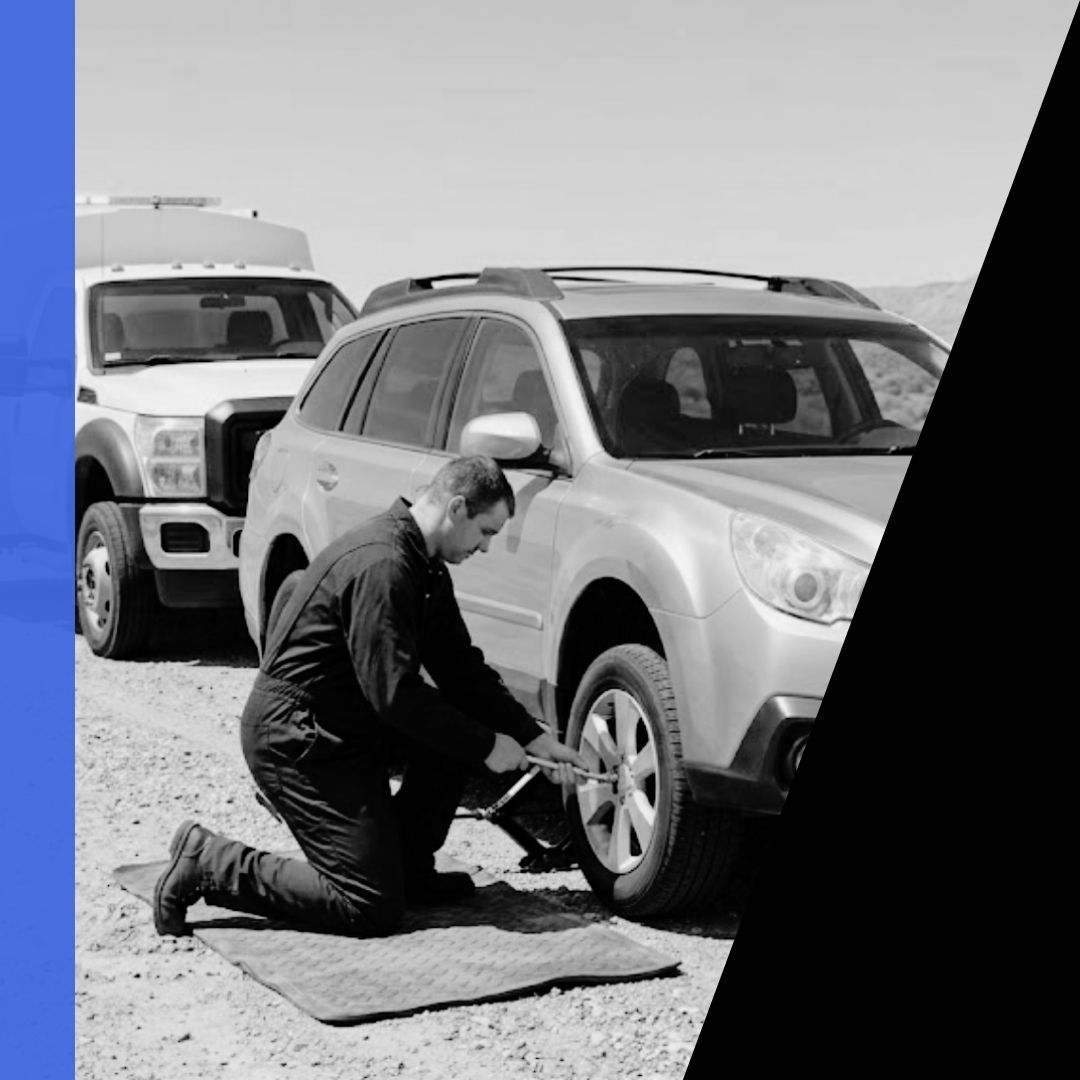 An unbranded mobile mechanic performs a roadside tire change on a Subaru Outback near Green River, Utah.
