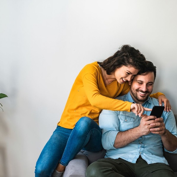 couple sitting and pointing to phone