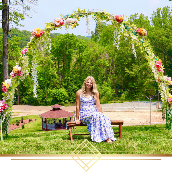 photo of woman in dress under large floral arch
