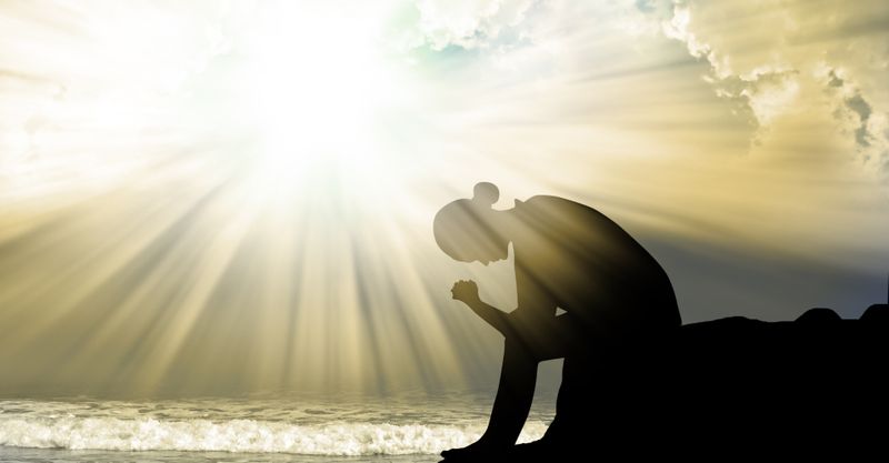 Woman praying under the sun