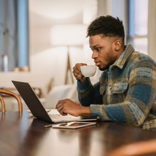 an African American man taking a sip of coffee as he's about to join an online church session image3.jpg