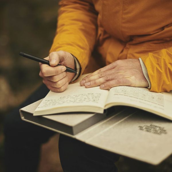 Person writing in a journal outside