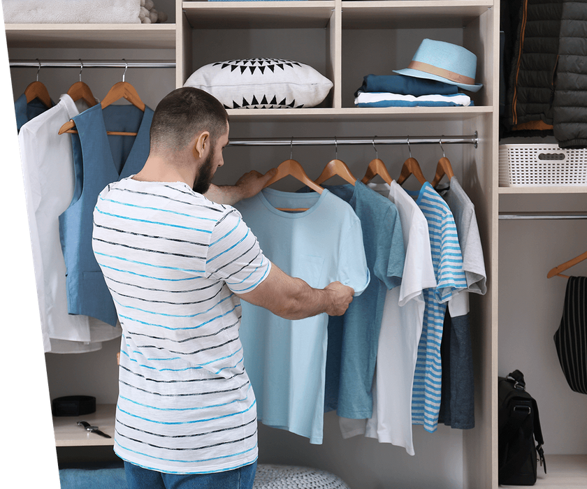 man selecting clothing from his closet