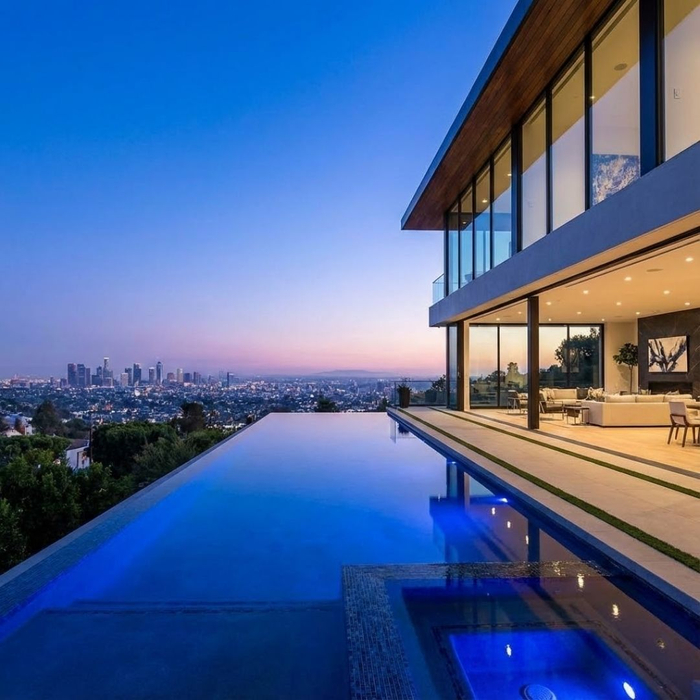 A modern luxury home with an infinity pool overlooking the Los Angeles skyline at dusk A modern luxury home with an infinity pool overlooking the Los Angeles skyline at dusk