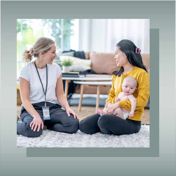 Healthcare worker talking to mother holding a baby