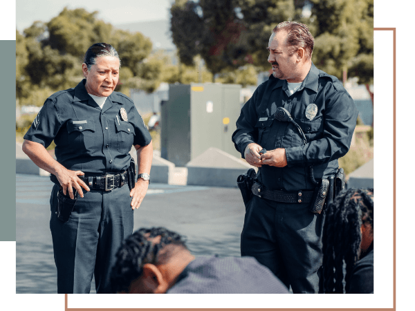 Two police officers in uniform discussing a traffic offense during a roadside driver stop